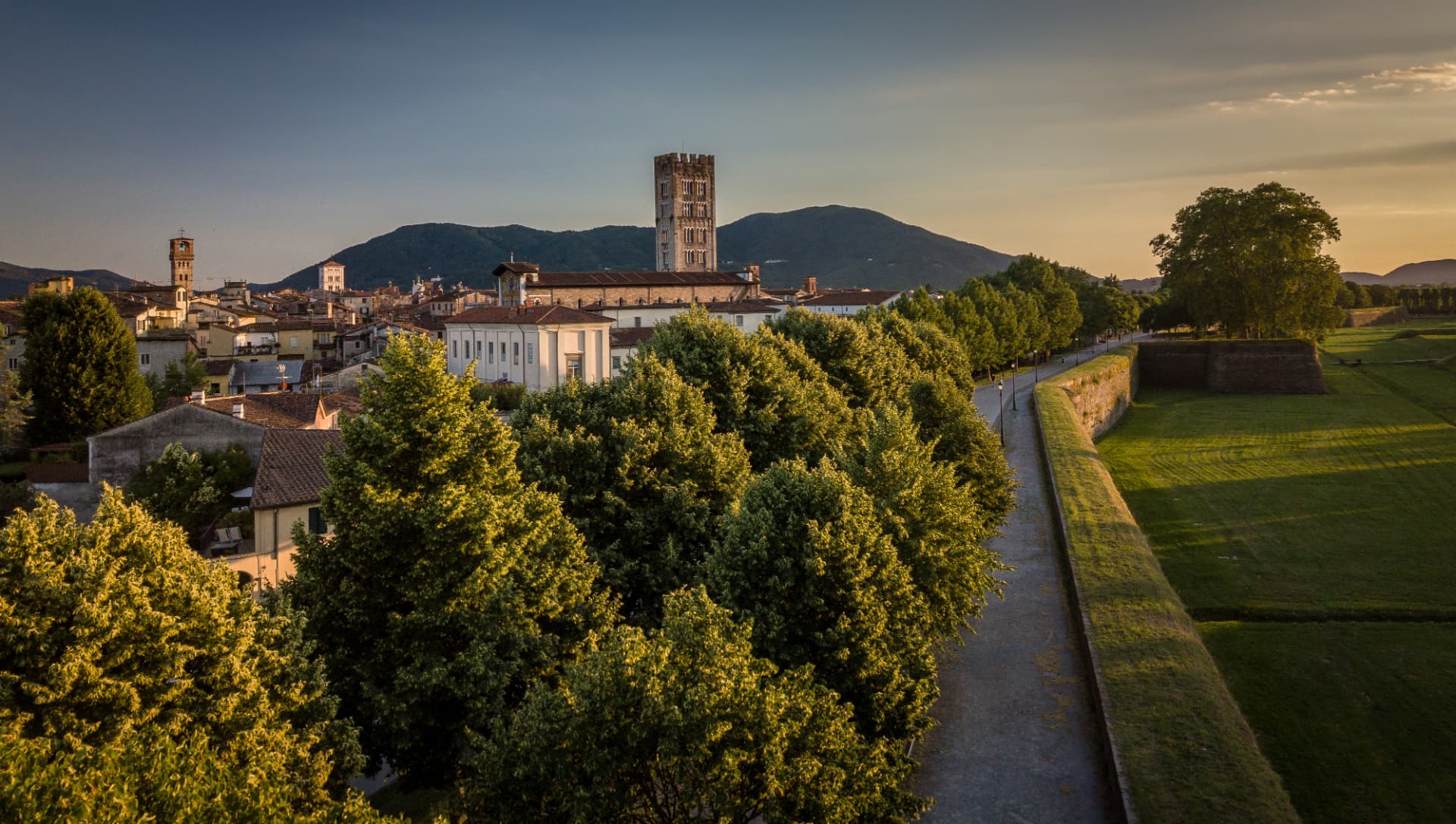 Le mura di Lucca al tramonto con la torre della basilica di San Frediano